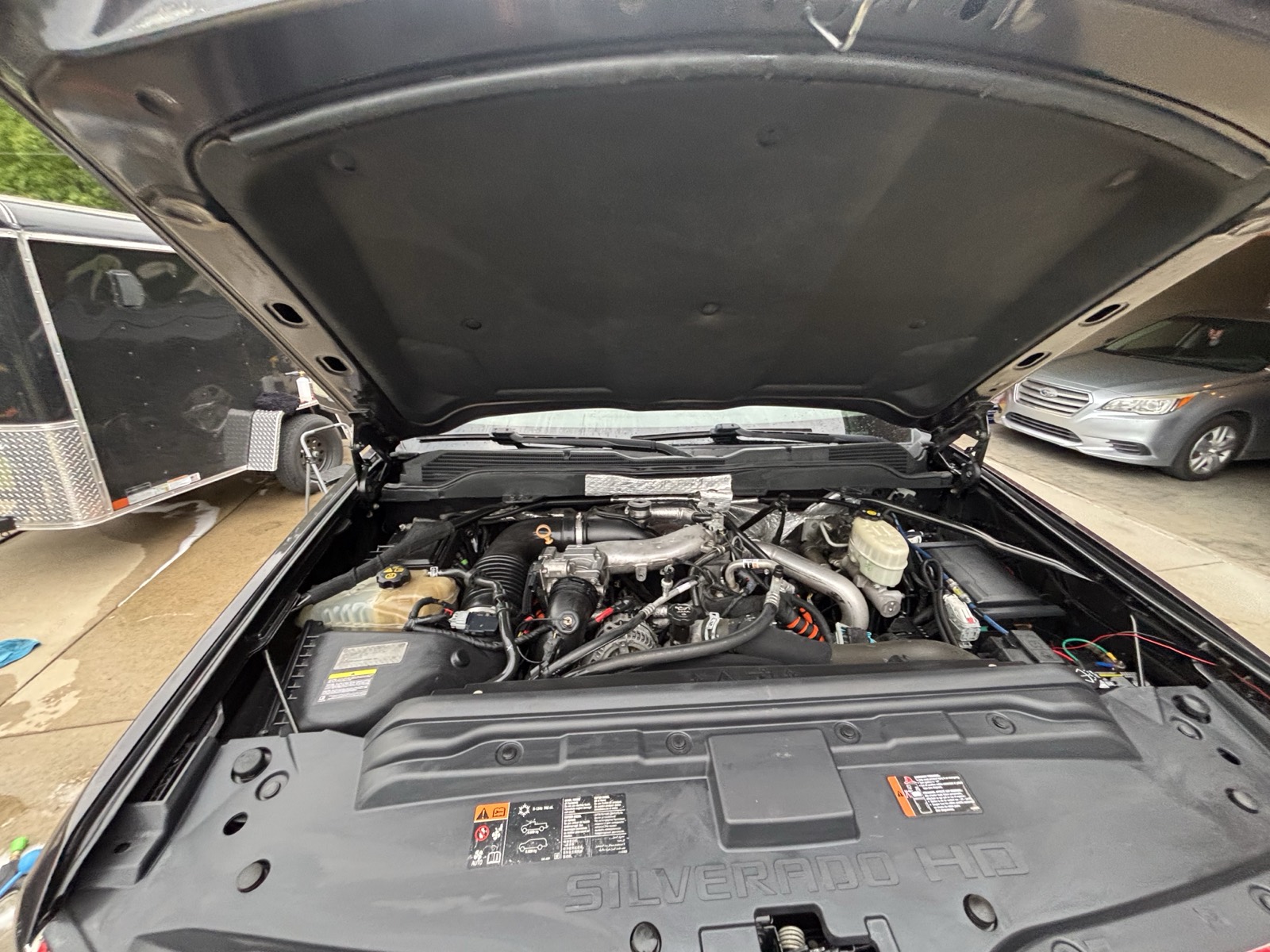 Chevy Silverado engine bay after detail — clean components, dressed plastics and rubber, factory-fresh appearance