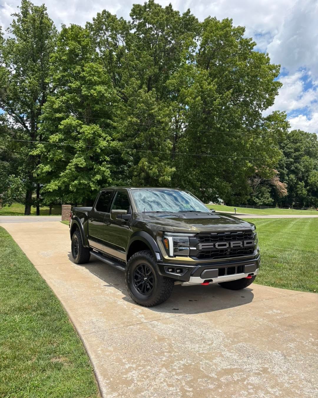 Black Ford F-150 Raptor in a driveway after full exterior detail — clean bodywork and glossy panels